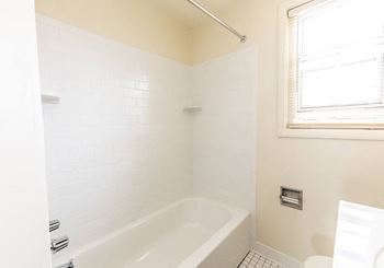 Bathroom with a white bathtub and a window